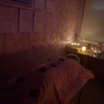 clienta en masaje con piedras calientes postrada boca abajo en una camilla